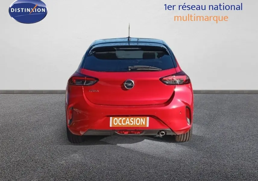 Vue arrière d'une Opel Corsa rouge métal avec toit noir, mettant en valeur ses feux et son logo central.