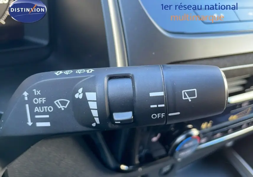 Gros plan sur la commande des essuie-glaces du Nissan Qashqai blanc nacré 2025 avec toit noir, intérieur noir.