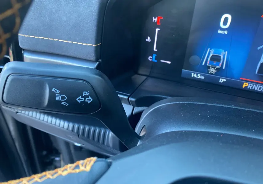 Gros plan sur le commodo gauche du tableau de bord du Ford Ranger 205 Wildtrak X, avec affichage numérique en arrière-plan.