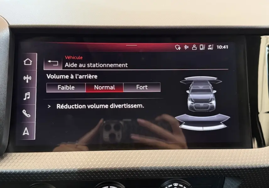 Écran tactile intérieur affichant l'aide au stationnement de l'Audi A1 noire vue de dessus en schéma digital.