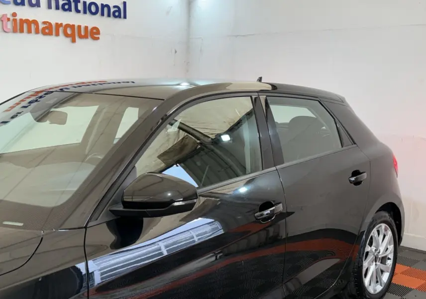 Audi A1 Business Line noire vue de profil côté gauche, avec rétroviseur et poignées de porte visibles.