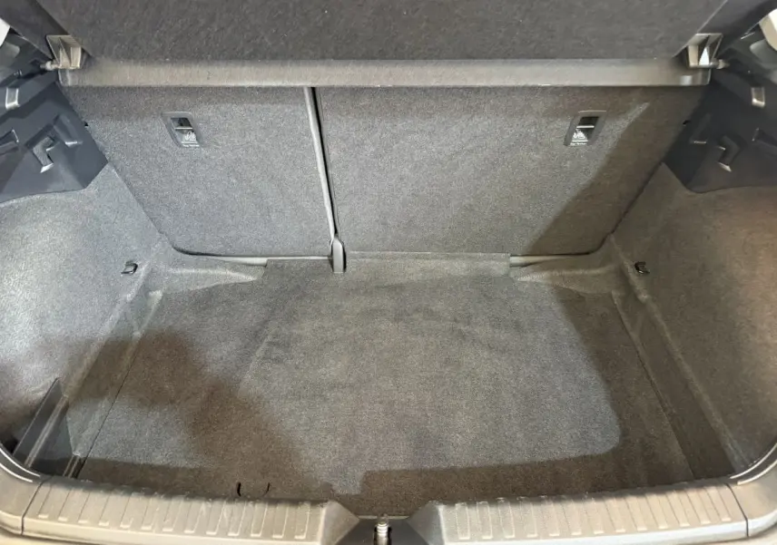 Vue intérieure du coffre spacieux et propre de l'Audi A1 noir, avec banquette arrière rabattable visible en arrière-plan.