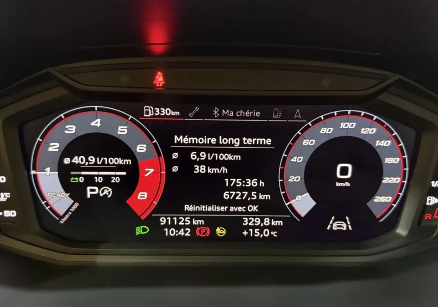 Tableau de bord numérique de l'Audi A1 noir, affichant la consommation, vitesse et informations de conduite.