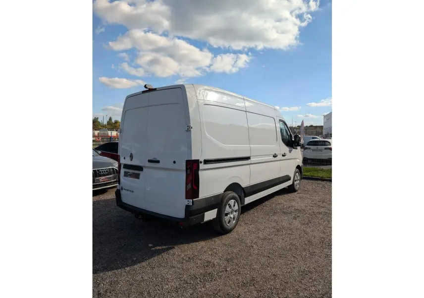 Renault Master blanc vu en 3/4 arrière droit, avec panneaux latéraux tôlés et attelage visible sous le pare-chocs.