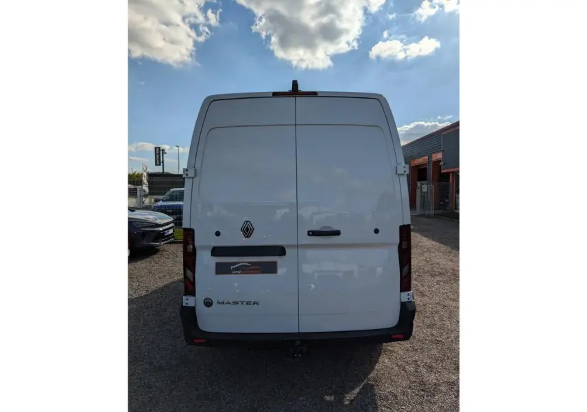 Vue arrière d'un Renault Master blanc avec portes battantes, logo central et attelage visible sous le pare-chocs.