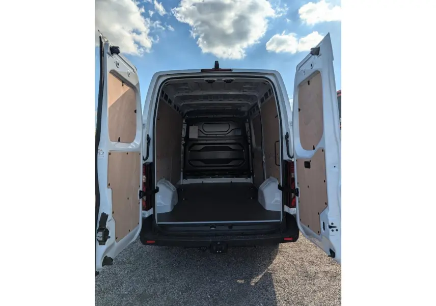 Vue arrière du Renault Master blanc 2025 avec portes ouvertes et habillage bois complet dans l'espace de chargement.