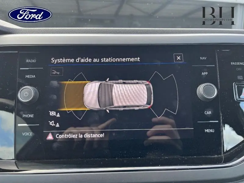Écran tactile du système d'aide au stationnement montrant une Volkswagen Polo Reflet d'Argent vue de dessus.