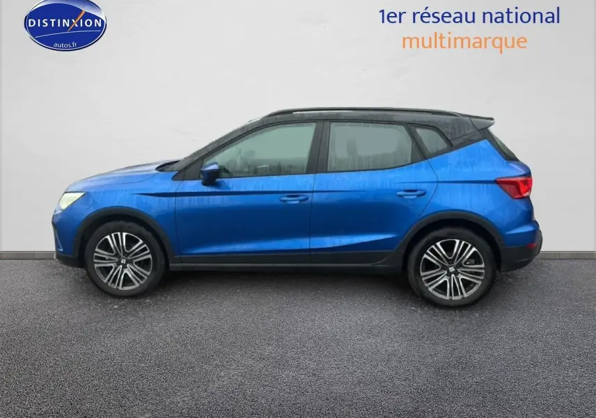 Vue de profil côté gauche d'un SEAT Arona 2025 bleu saphir avec toit noir et jantes 17 pouces urban design.