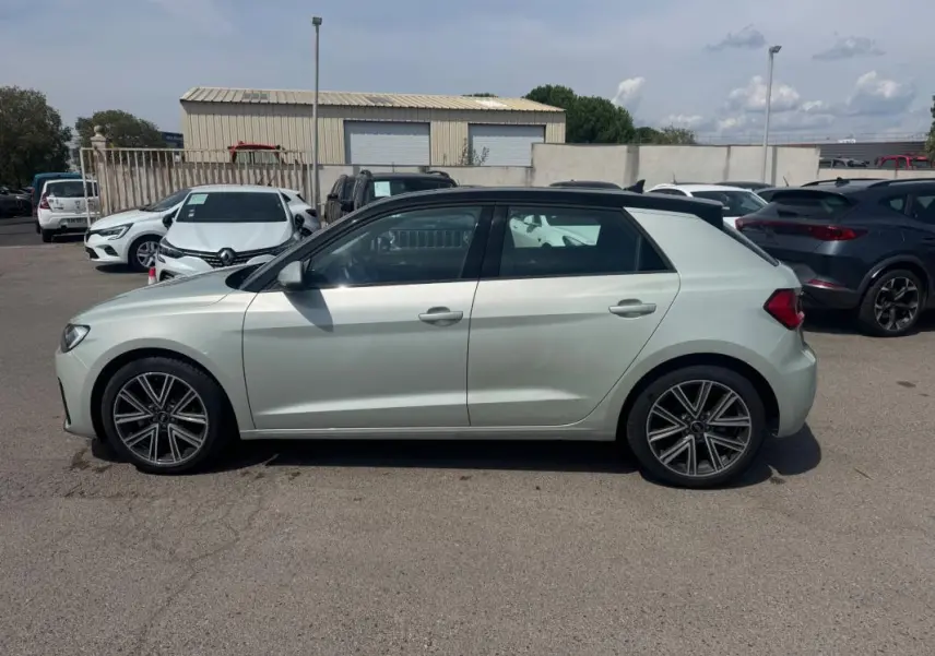 Audi A1 Sportback gris vue de profil côté gauche, avec jantes alliage et toit noir contrasté visible.