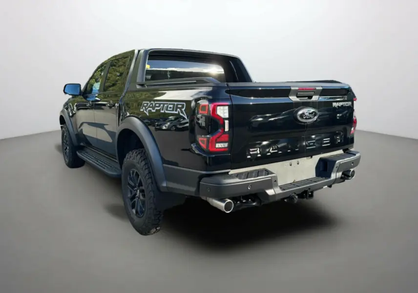 Vue 3/4 arrière gauche du Ford Ranger Raptor 2024 noir absolu avec logo distinctif et double sortie d'échappement.