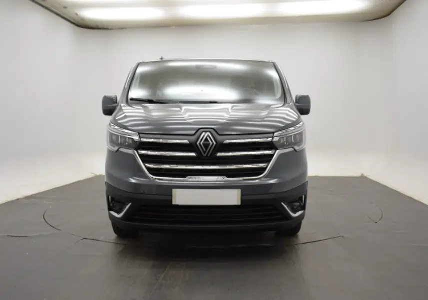 Vue frontale du Renault Trafic Fourgon gris clair, mettant en valeur sa calandre chromée et ses phares LED.