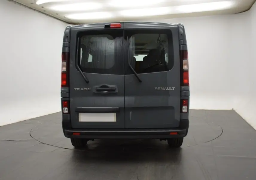 Vue arrière du Renault Trafic Fourgon gris clair avec portes battantes et essuie-glaces intégrés aux vitres arrière.