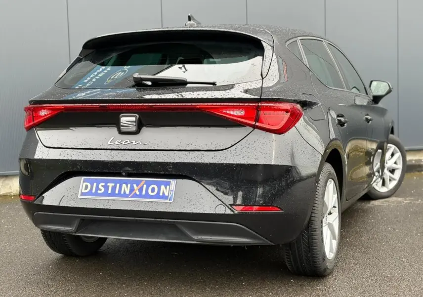 Vue 3/4 arrière droite d'une SEAT Leon 2024 noir minuit avec feux arrière LED et jantes alliage 16 pouces.