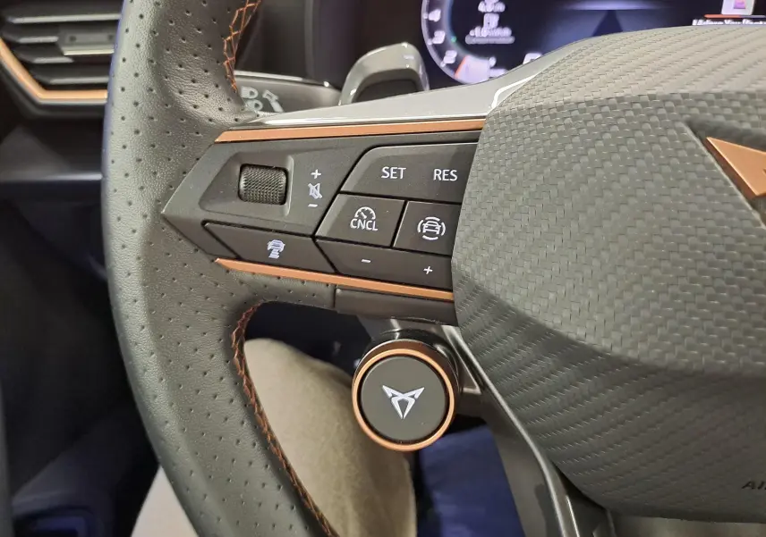 Gros plan sur le volant perforé noir avec inserts cuivrés et commandes multifonctions du CUPRA Formentor 2025.