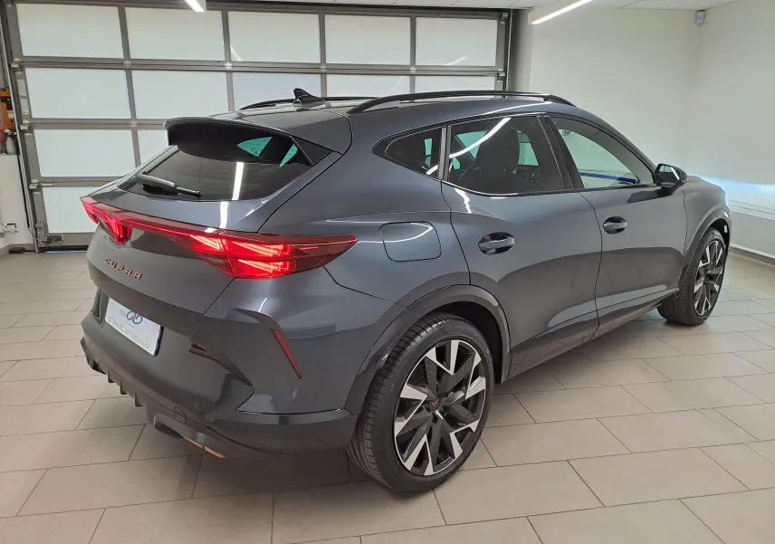 Vue 3/4 arrière droite du CUPRA Formentor gris magnétique avec jantes alliage 19'' et feux arrière Tri-LED allumés.