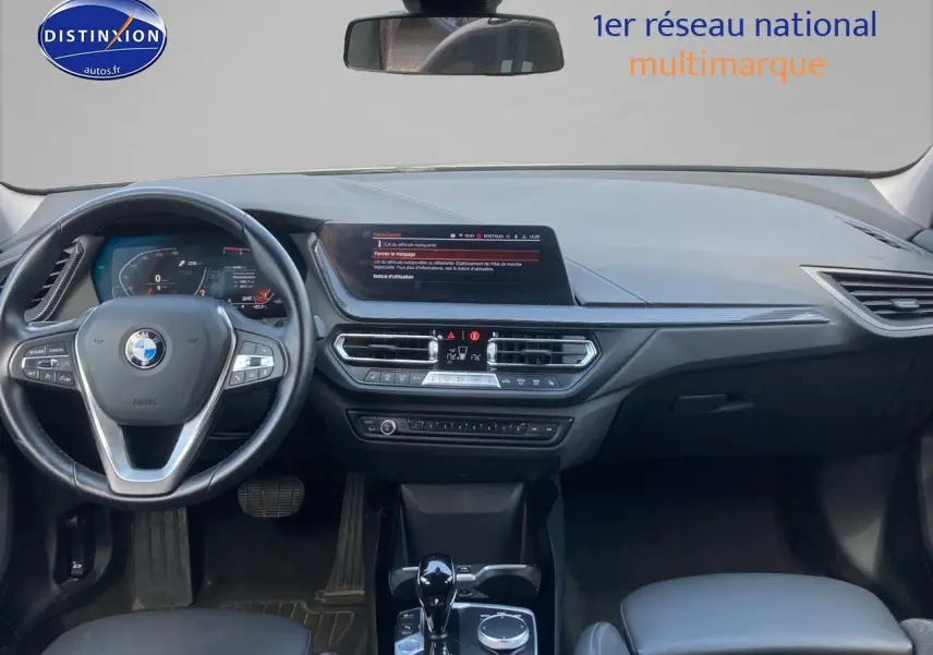 Vue intérieure du tableau de bord et volant noir de la BMW Série 1 F40 118i 2023 avec écran central et commandes multifonctions.
