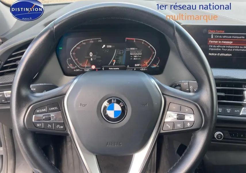 Vue rapprochée du volant sport en cuir noir de la BMW Série 1 (f40) 118i 2023 avec tableau de bord digital allumé.