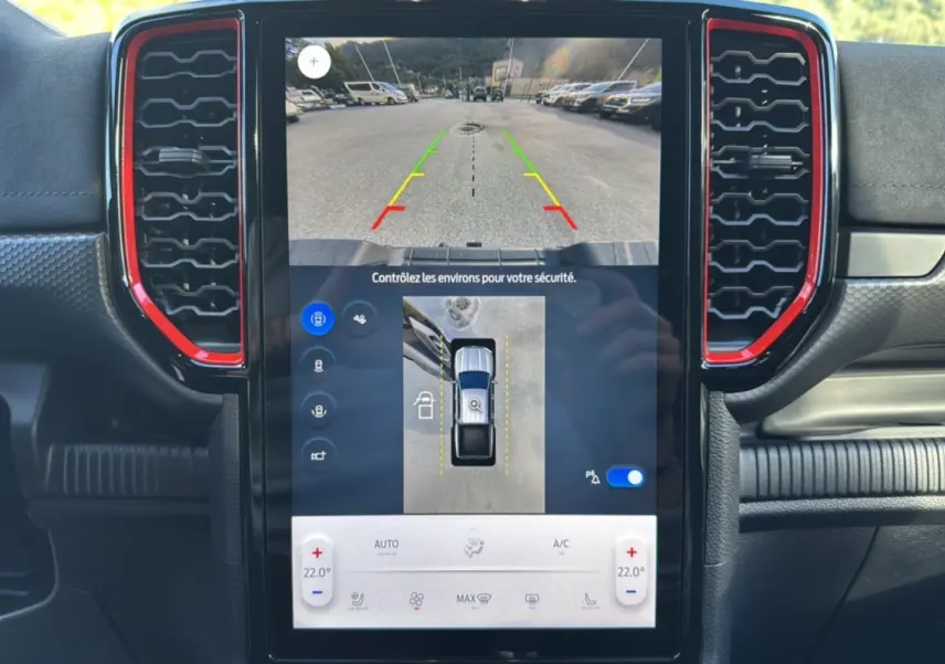 Vue intérieure du tableau de bord du Ford Ranger Raptor 2024, écran tactile avec caméra de recul et aérateurs rouges.