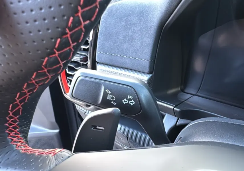 Gros plan sur le volant en cuir noir avec surpiqûres rouges et la commande des clignotants du Ford Ranger Raptor 2024.