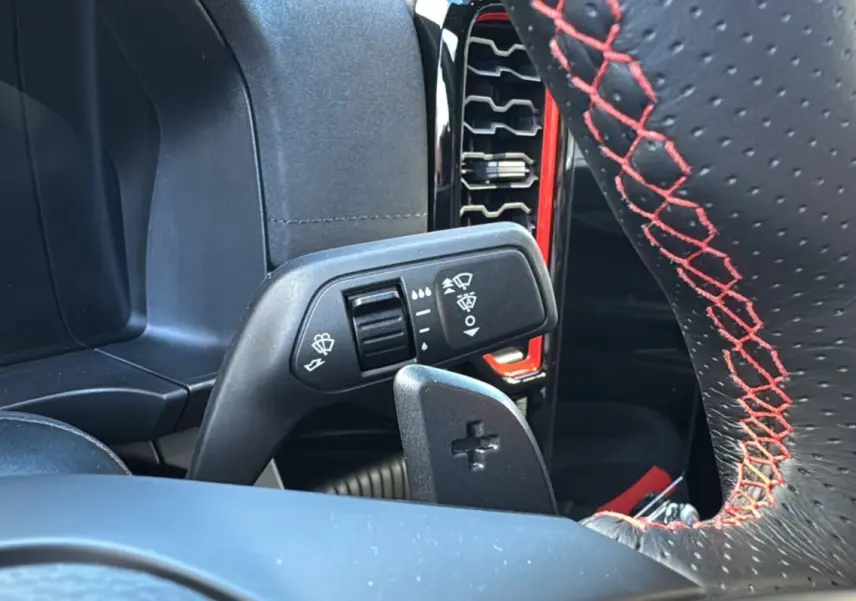 Gros plan sur la commande d'essuie-glace et le volant noir à surpiqûres rouges du Ford Ranger Raptor 2024.