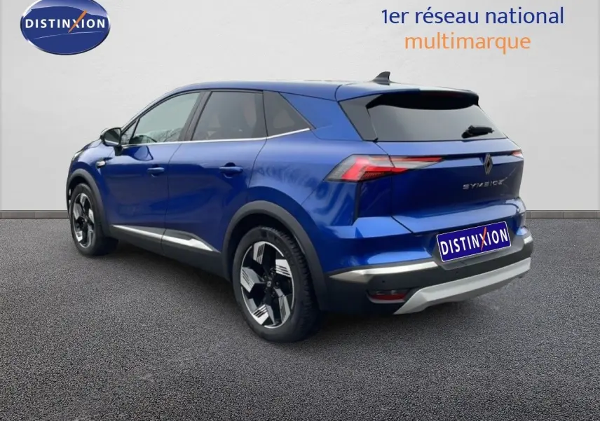 Renault Symbioz E-Tech hybride bleu Iron Metal, vue 3/4 arrière droit avec jantes noires et détails argentés.