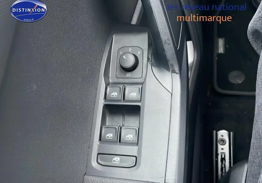 Vue rapprochée des commandes de lève-vitres et rétroviseurs côté conducteur du SEAT Arona blanc Nevada 2025.