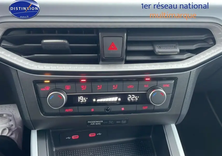 Vue rapprochée de la console centrale du SEAT Arona blanc Nevada, affichant la climatisation automatique bi-zone.