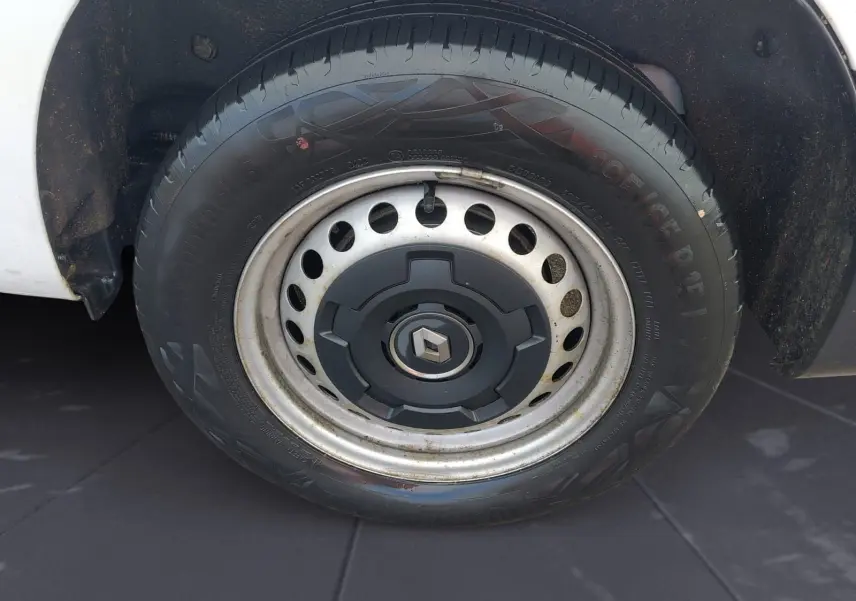 Gros plan sur la roue avant gauche blanche d’un Renault Kangoo 2022 avec jante acier et logo Renault central.