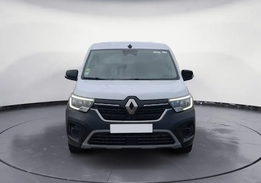 Vue frontale d'un Renault Kangoo blanc 2022 avec calandre noire et phares LED allumés dans un studio.