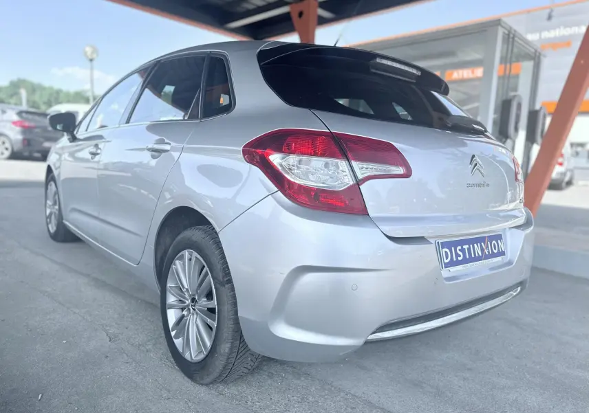 Vue 3/4 arrière gauche d'une Citroën C4 gris métallisé, avec feux arrière distinctifs et jantes alliage.