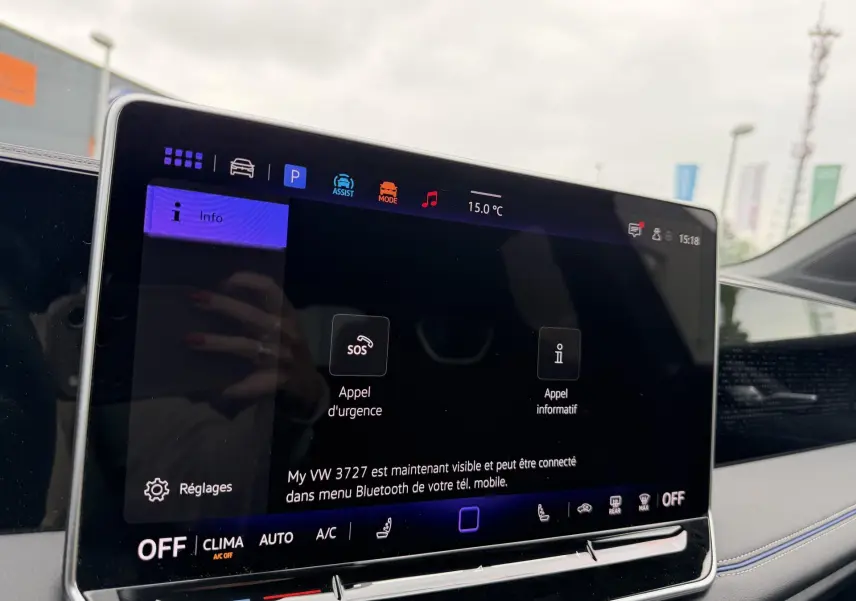Écran tactile central du Volkswagen Tiguan 2025 avec interface digitale, vue intérieure côté passager, ambiance lumineuse grise.