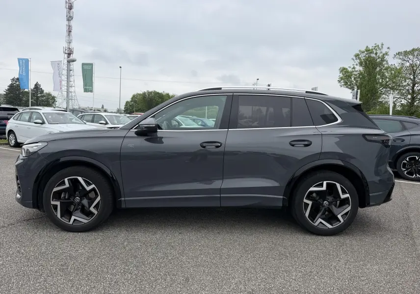Vue de profil côté gauche d'un Volkswagen Tiguan gris 2025 avec jantes alliage 19 pouces et vitres teintées.