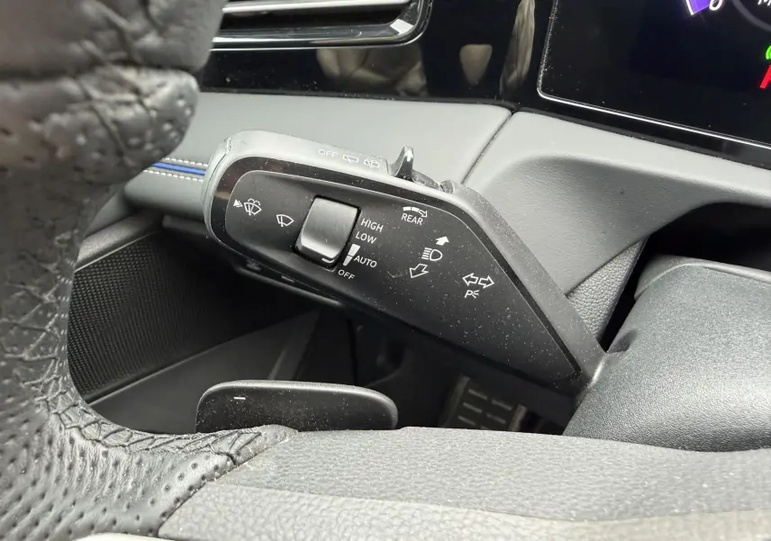 Gros plan sur la manette de commande des essuie-glaces et clignotants du Volkswagen Tiguan 2025, intérieur noir.