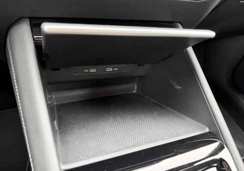 Vue rapprochée de la console centrale du Volkswagen Tiguan 2025, avec compartiment ouvert et ports USB visibles.
