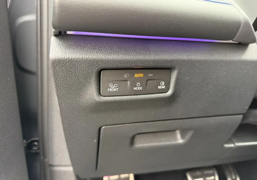 Gros plan sur le panneau de commande d’éclairage intérieur gris du Volkswagen Tiguan 2025 avec éclairage automatique activé.