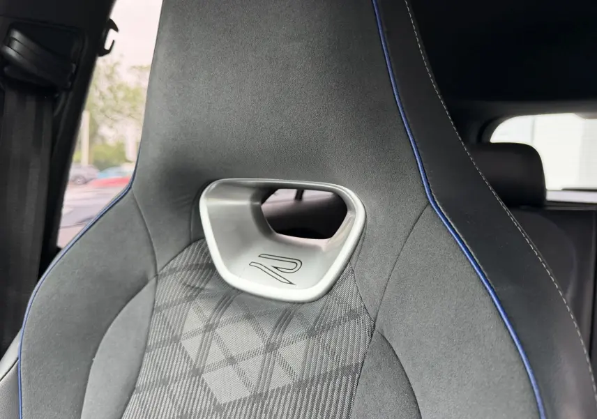 Gros plan sur le siège avant sport gris avec surpiqûres bleues et logo R du Volkswagen Tiguan 2025.