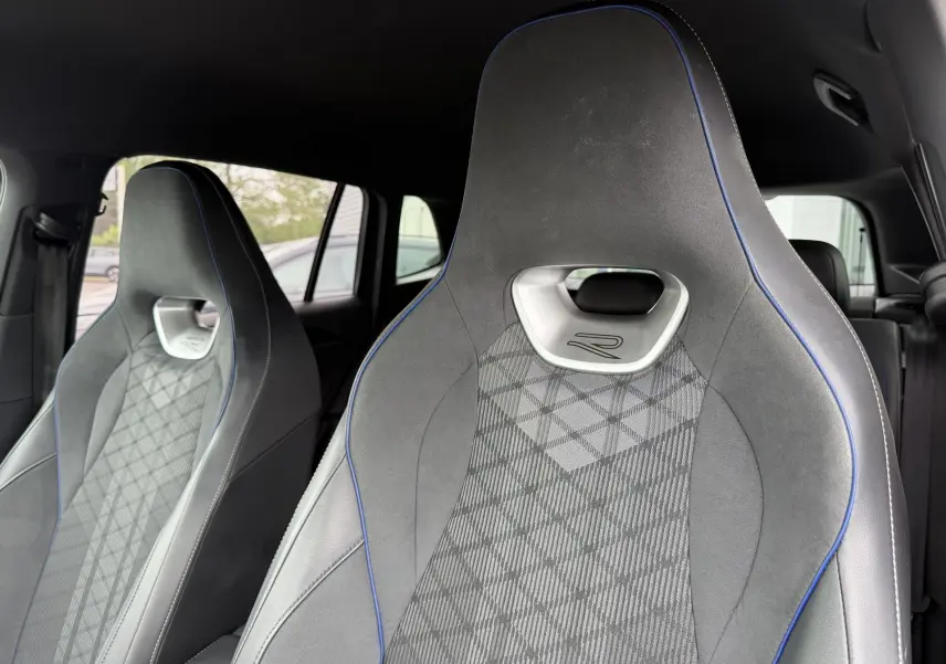 Gros plan sur les sièges avant sport gris avec surpiqûres bleues et logo R du Volkswagen Tiguan 2025.