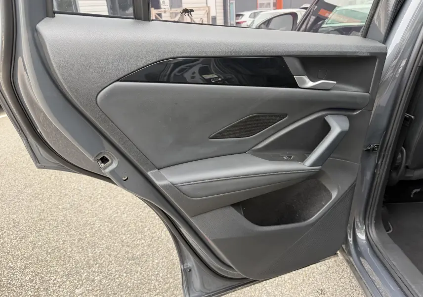 Vue intérieure de la porte arrière droite grise du Volkswagen Tiguan 2025 avec garniture noire et poignée argentée.