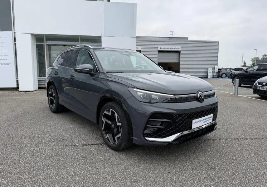 Volkswagen Tiguan gris 3/4 avant droit avec jantes alliage 19 pouces et calandre noire distinctive.