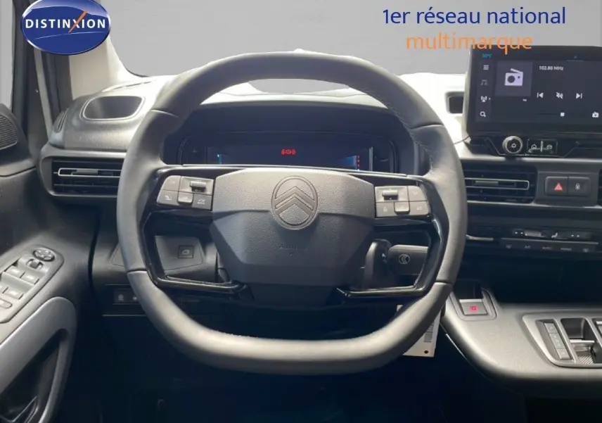 Vue intérieure centrée sur le volant noir d’un Citroën Berlingo 2026 avec tableau de bord et écran tactile.