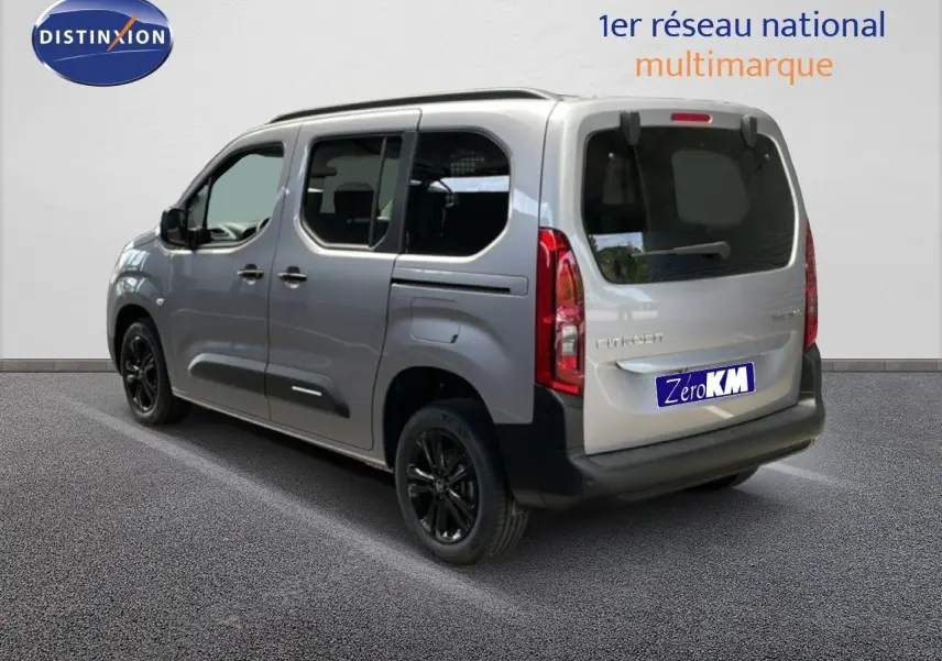 Vue 3/4 arrière droite d'un Citroën Berlingo gris Artense métallisé avec jantes noires et vitres teintées.