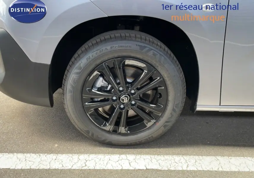 Gros plan sur la roue avant droite noire brillante du Citroën Berlingo gris Artense métal.