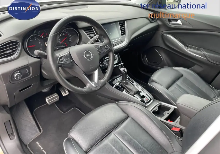 Intérieur avant droit de l'Opel Grandland X 2018 avec sièges cuir noir et console centrale équipée d'une boîte automatique.