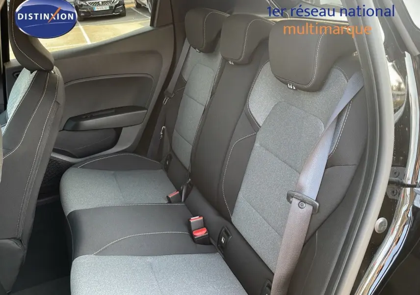 Vue intérieure sur les sièges arrière en tissu gris et noir de la Renault Clio 1.5 DCI 2025 avec porte arrière ouverte.