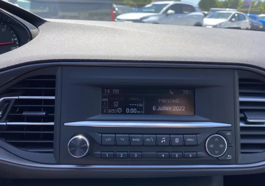 Vue rapprochée du tableau de bord noir de la Peugeot 308 SW 2017 avec écran central et commandes radio.