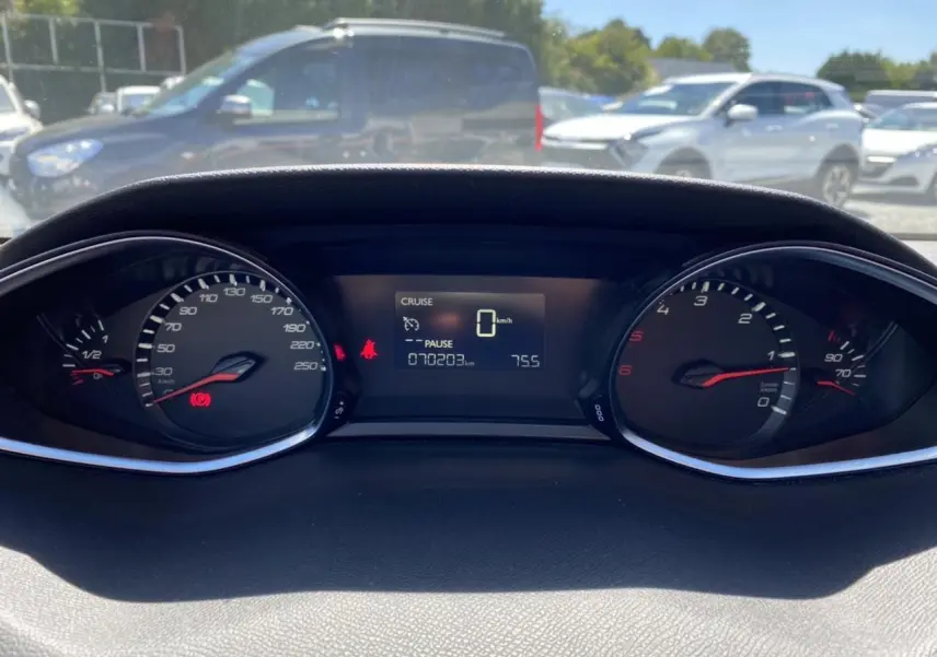 Vue rapprochée du tableau de bord numérique d'une Peugeot 308 SW gris clair, affichant 70 203 km et vitesse à zéro.