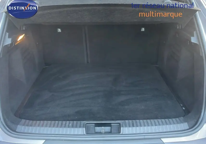 Coffre ouvert vu de l'arrière d'une Renault Symbioz gris cassiopée métal, espace de chargement vide et propre.