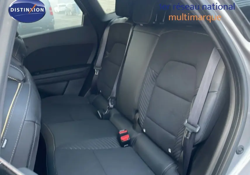 Vue intérieure arrière côté droit montrant les sièges en tissu noir avec surpiqûres contrastantes du Renault Symbioz gris cassiopée métal.