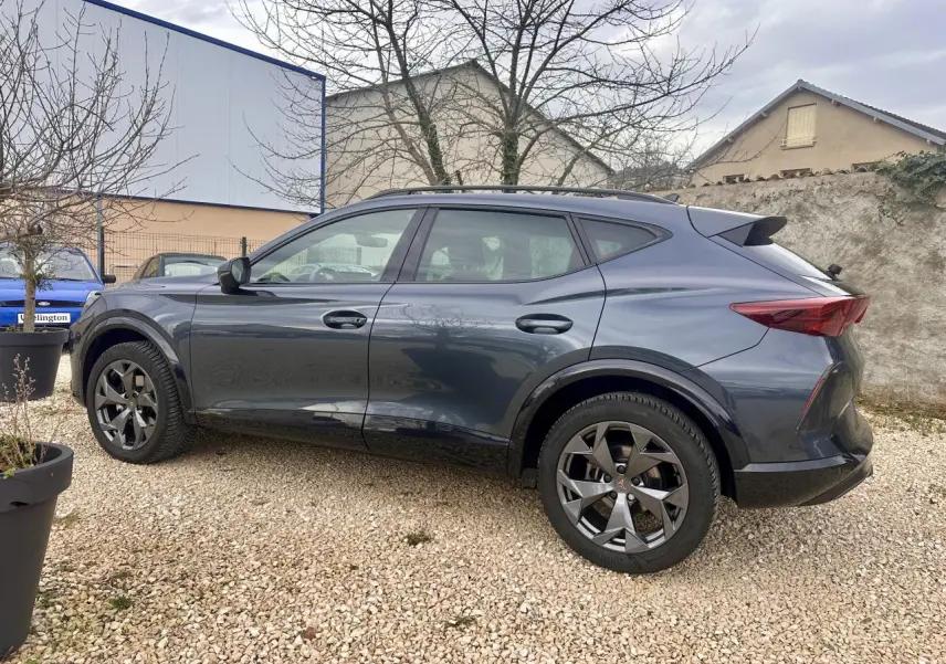 Vue de profil côté gauche du CUPRA Formentor gris 2025 avec jantes noires et toit surélevé.