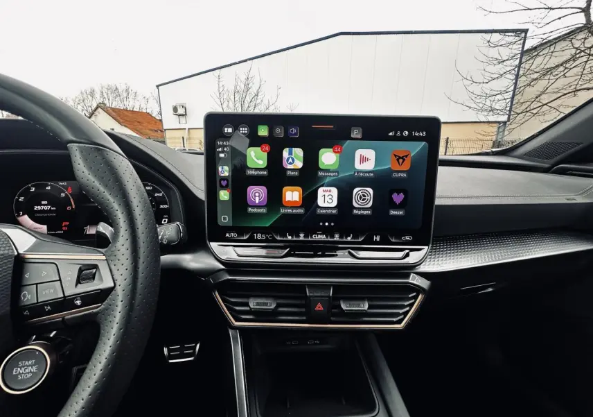 Vue intérieure centrée sur l'écran tactile HD 12,9" et le volant perforé du CUPRA Formentor gris 2025.